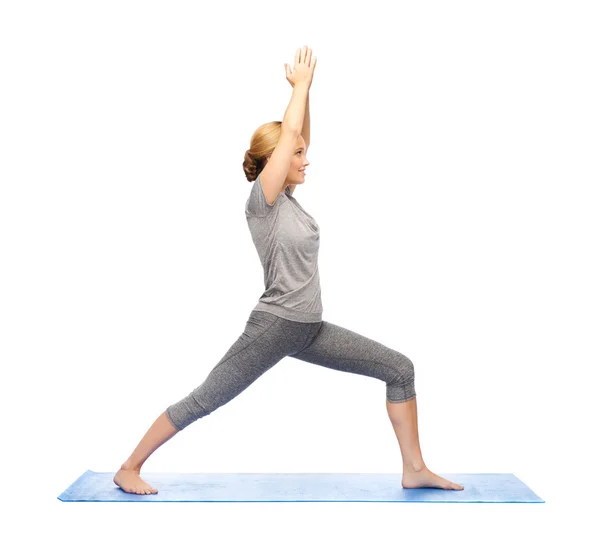 Kadın yapma yoga savaşçı poz mat — Stok fotoğraf