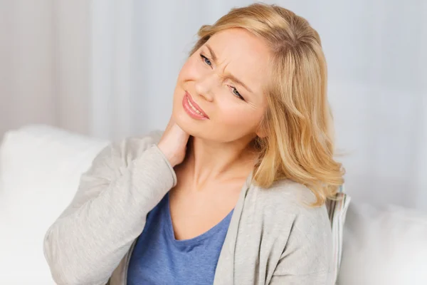Unhappy woman suffering from neck pain at home — Stock Photo, Image