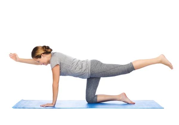 Vrouw maken yoga in evenwicht brengen van tabel pose op de mat — Stockfoto