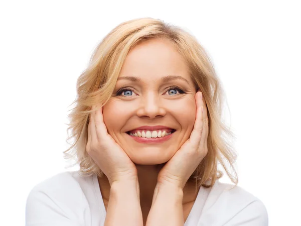 Mulher sorridente em t-shirt branca tocando seu rosto — Fotografia de Stock
