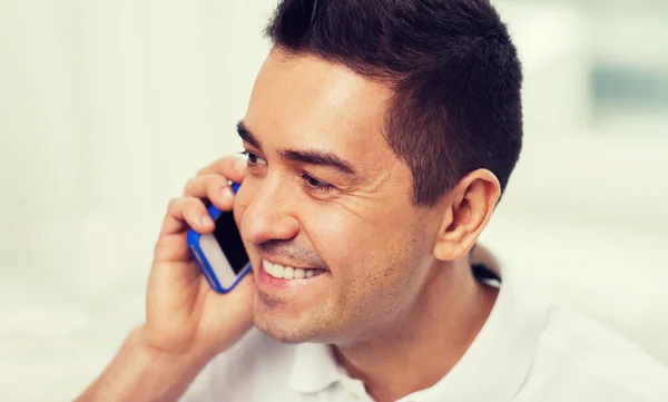 Happy man calling on smartphone at home — Stock Photo, Image