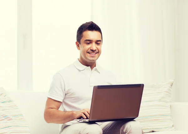 Ευτυχισμένος άνθρωπος που εργάζεται με το φορητό υπολογιστή στο σπίτι — Φωτογραφία Αρχείου