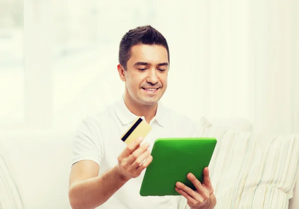 Sorrindo homem trabalhando com tablet pc em casa — Fotografia de Stock