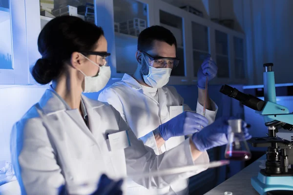 Perto de cientistas que fazem testes em laboratório — Fotografia de Stock