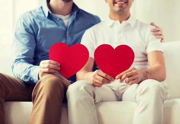 Close up of happy gay male couple with red hearts — Stock Photo, Image