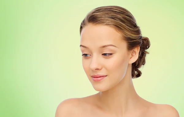 Smiling young woman face and shoulders over green — Stock Photo, Image