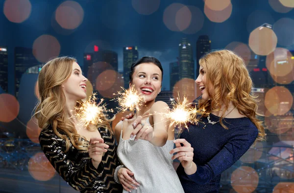 Jeunes femmes heureuses avec des étincelles sur la ville de nuit — Photo