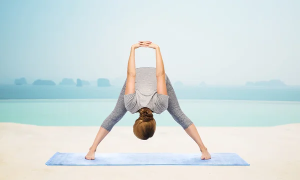 Frau macht Yoga breitbeinig nach vorne beugen auf Matte — Stockfoto