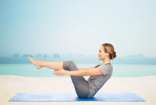 Frau macht Yoga in Halbboot-Pose auf Matte — Stockfoto