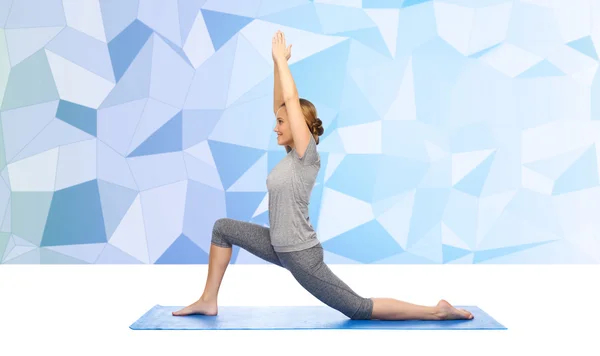 Gelukkige vrouw maken yoga in lage longe op mat — Stockfoto