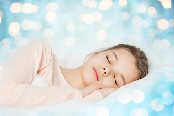 Chica durmiendo en cama sobre azul luces fondo —  Fotos de Stock