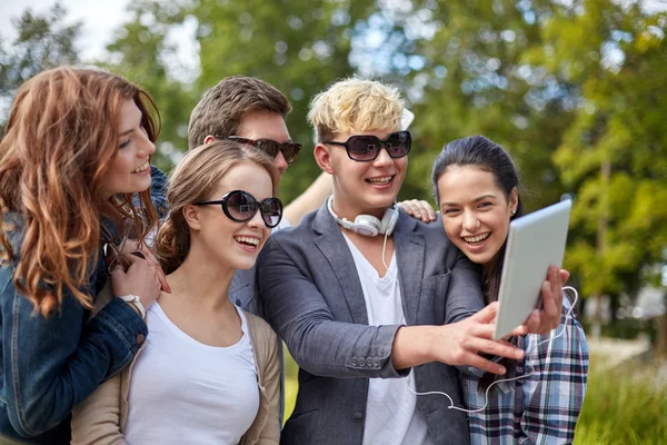 Students or teenagers with tablet pc taking selfie — Stock Photo, Image