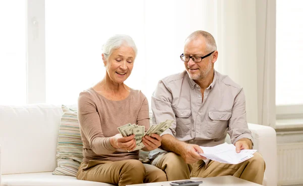 Senior paar met geld en rekenmachine thuis — Stockfoto