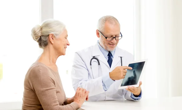 Mosolygó idősebb nő és orvos-val tabletta pc — Stock Fotó