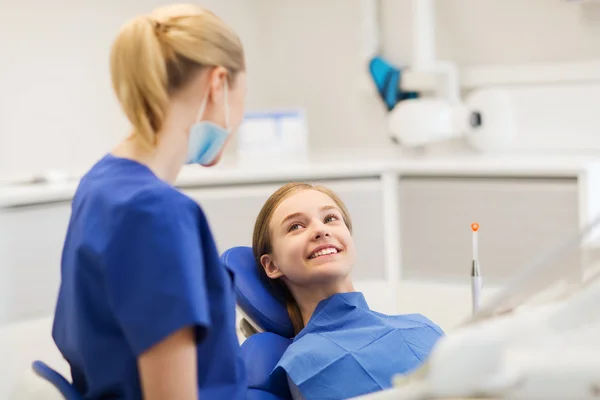 Gelukkig vrouwelijke tandarts met meisje van de patiënt bij kliniek — Stockfoto