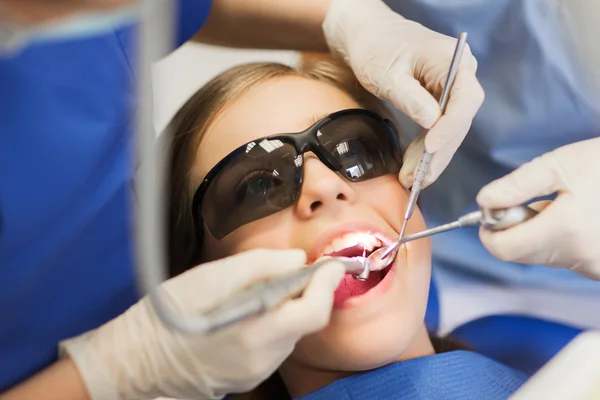 Female dentists treating patient girl teeth — Stock Photo, Image