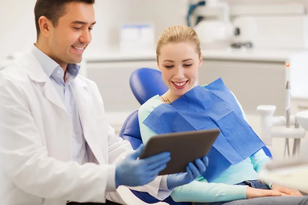 Стоматолог-мужчина с планшетным ПК и пациентка — стоковое фото