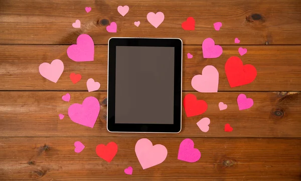 Close up of tablet pc and hearts on wood — Stock Photo, Image