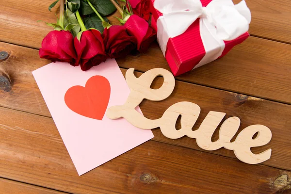 Close up of gift box, red roses and greeting card — Stock Photo, Image