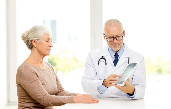 Senior vrouw en arts met tablet pc Stockafbeelding