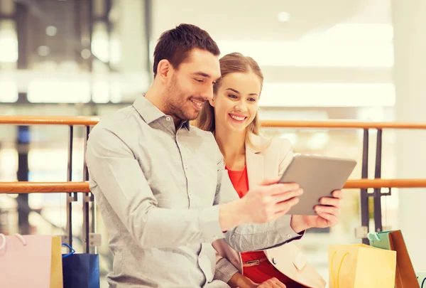 Coppia con tablet pc e shopping bags nel centro commerciale — Foto Stock