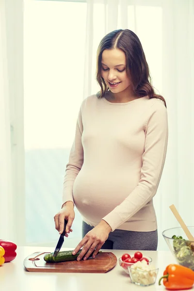 Mujer embarazada feliz preparando comida en casa —  Fotos de Stock