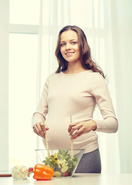 Mujer embarazada feliz preparando comida en casa —  Fotos de Stock