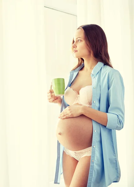 Mulher grávida feliz com xícara beber chá em casa — Fotografia de Stock