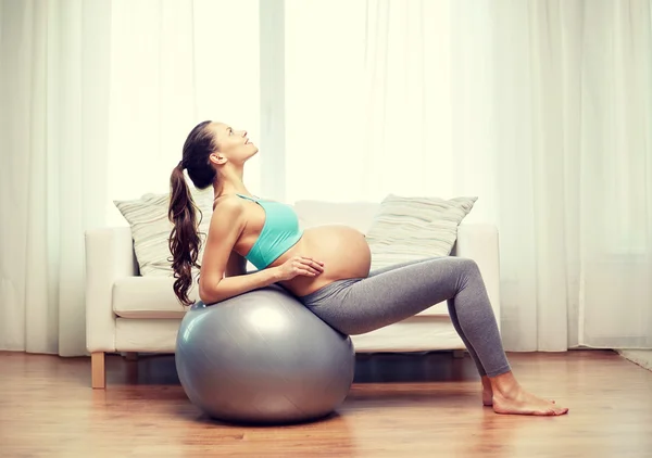 Mulher grávida feliz exercitando em fitball em casa — Fotografia de Stock