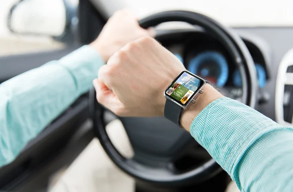 Close up of male hands with smartwatch driving car — Stock Photo, Image