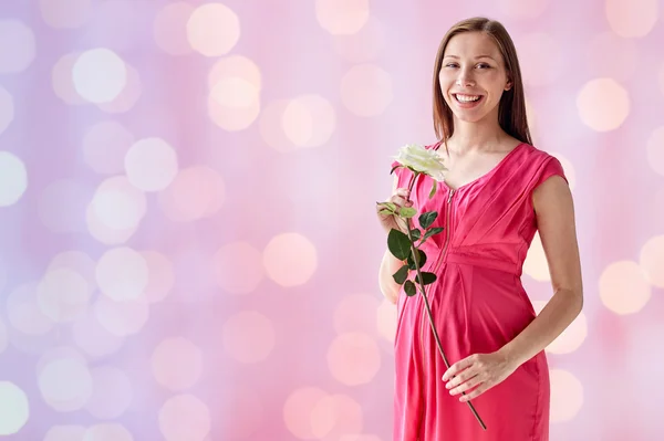 Ευτυχισμένη έγκυος γυναίκα με το ροδαλό λουλούδι — Φωτογραφία Αρχείου