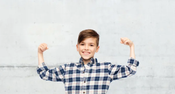 Menino feliz em camisa quadriculada mostrando punhos fortes — Fotografia de Stock