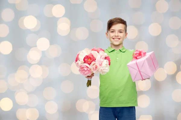 Niño feliz sosteniendo ramo de flores y caja de regalo —  Fotos de Stock