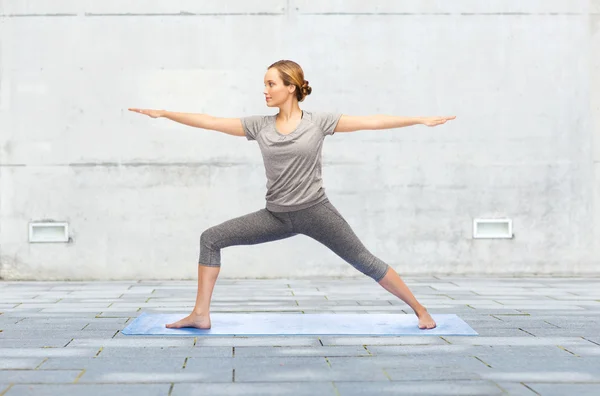 Donna che fa yoga guerriero posa su mat — Foto Stock