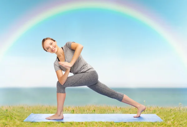 Жінка робить йогу під низьким кутом позування на килимку — стокове фото