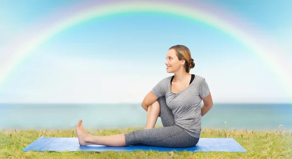 Mujer haciendo yoga en actitud de giro en la estera —  Fotos de Stock