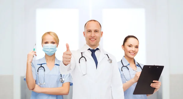 Group of doctors at hospital showing thumbs up — ストック写真