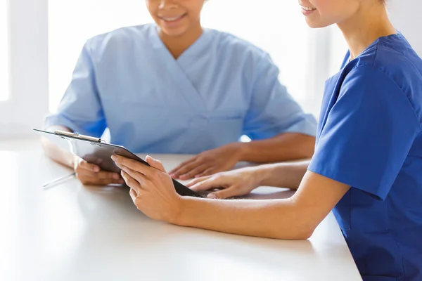 Close up of doctors with clipboard at hospital — Stock Photo, Image
