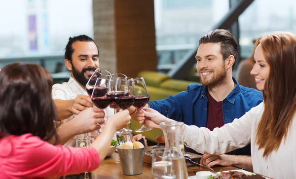 Barátok étkezési és ivási bor étteremben — Stock Fotó