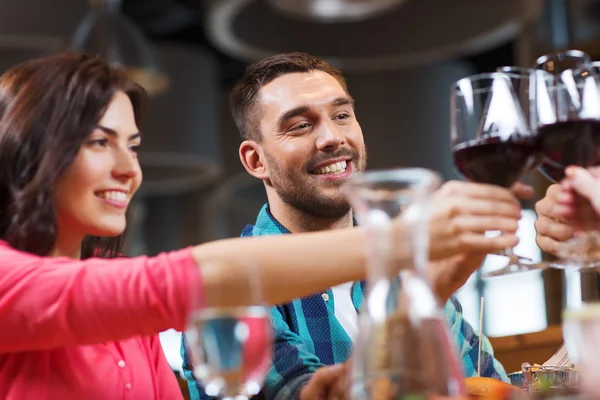 Friends clinking glasses of wine at restaurant — Stock Photo, Image