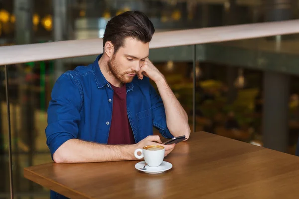 Hombre con teléfono inteligente y café en el restaurante —  Fotos de Stock