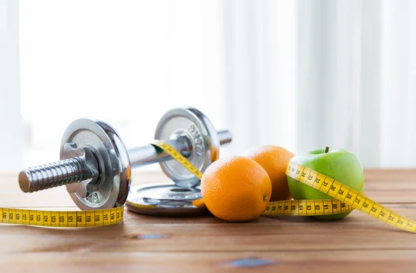 Close up of dumbbell, fruits and measuring tape — Stock Photo, Image