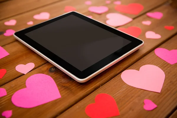 Close up of tablet pc and hearts on wood — Stock Photo, Image