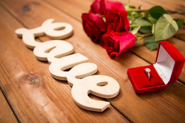 Close up of diamond ring, red roses and word love — Stock Photo, Image