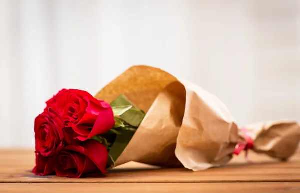 Primer plano de rosas rojas manojo envuelto en papel —  Fotos de Stock