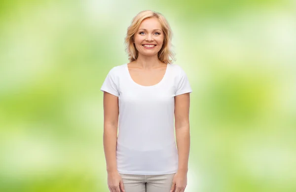 Усміхнена жінка середнього віку в порожній білій футболці Стокове Фото