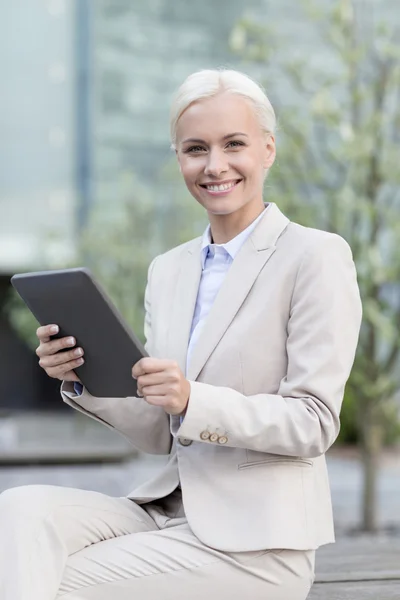 Glimlachende zakenvrouw met tablet pc buitenshuis — Stockfoto