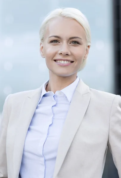 Jeune femme d'affaires souriante sur immeuble de bureaux — Photo