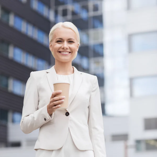 Smiling businesswoman with paper cup outdoors — Stock Photo, Image