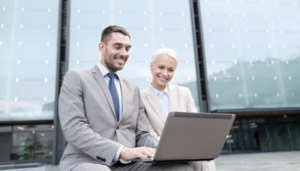 Uomini d'affari sorridenti con computer portatile all'aperto — Foto Stock